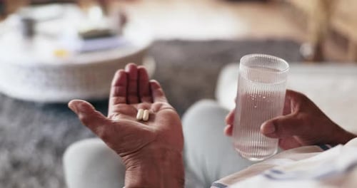Senior Adult Holding Medication and Water