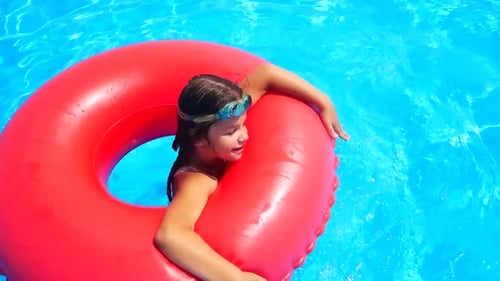 Little Girl Jumps Into an Inflatable Circle with a Pool Side Children Have Fun and Play Dives on the