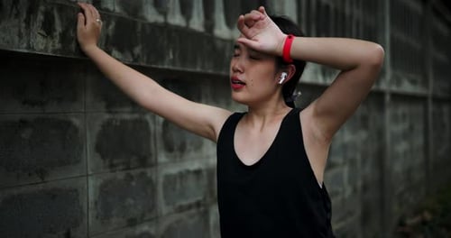 Woman Resting After Running in Urban Setting