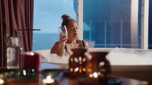 Woman Relaxes in Bubble Bath with Drink