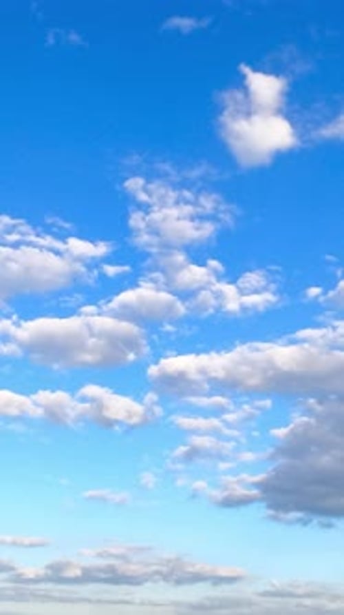 Große und separate kleine Wolken schweben am herrlichen blauen Himmel.