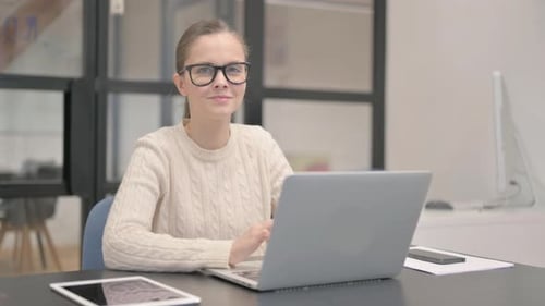 Young Woman Smiling at Camera in Office