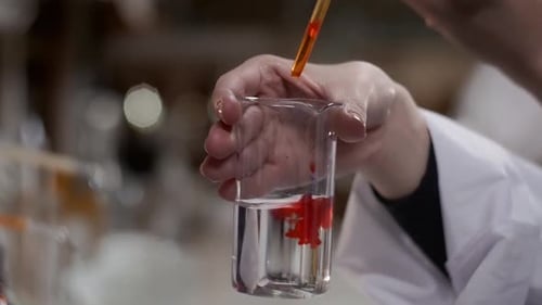 Red Liquid Mixing in Beaker in Laboratory Setting