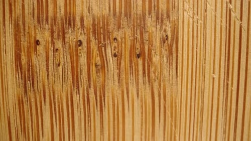 Texture and fibers of a bamboo cutting board, with knife marks. Macro slider.