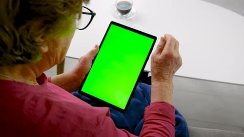 Old Woman Look at Tablet Green Background