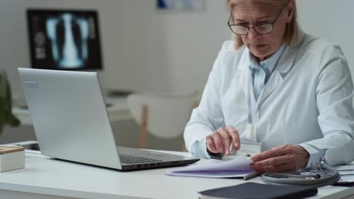 Doctor Working at Laptop in Medical Office