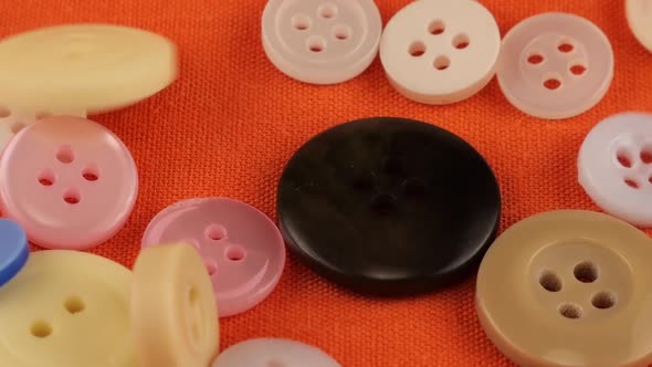 Colorful Buttons Falling onto Orange Fabric Background, Slow Motion ...
