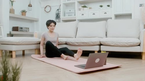 Woman Does Yoga at Home with Laptop