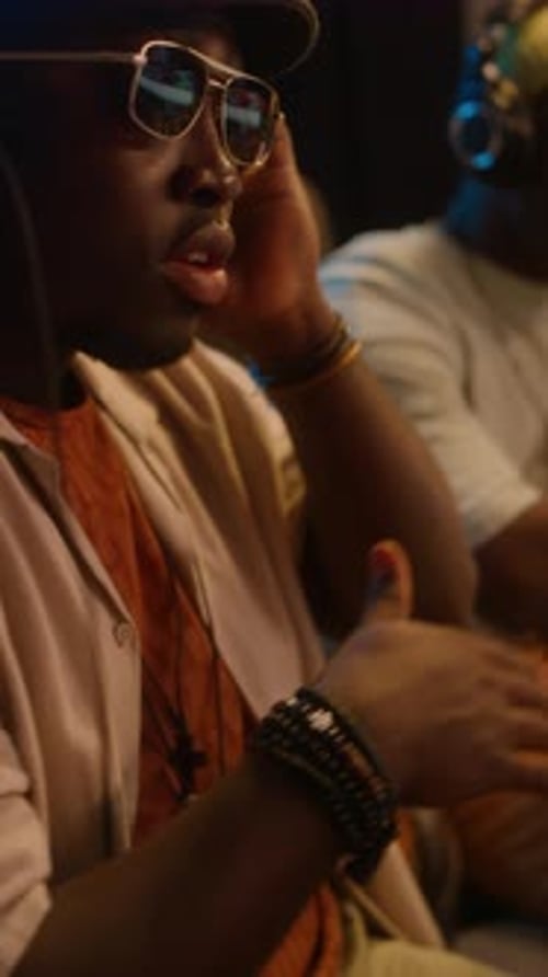 Black Male Hip-Hop Producer Listening to New Track in Recording Studio