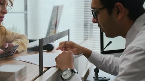 Bank Assistant Explaining Legal Document Forms to Woman