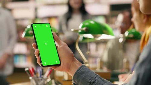 Vertikales Greenscreen-Modell auf dem Telefon, das während der Lernsitzung in der Hand gehalten wird