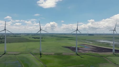 Cinematic Slow Motion Aerial view of Wind Farm Turbines foreground reveal. Renewable Energy.