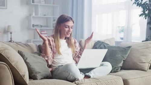 Woman Video Calling on Laptop at Home on Couch