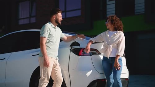 Young Couple Charging Electric Car Together