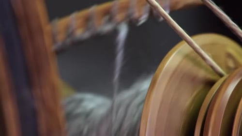 Narrow focus close-up: Yarn on bobbin of antique Nordic spinning wheel