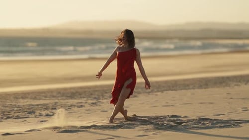 Graceful Emotional Woman in a Red Dress Dancing on the Beach