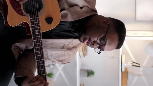 Adult Male Playing Acoustic Guitar and Singing