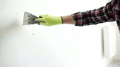 Adult Repairing Wall with Trowel Indoors