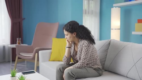 Woman Cries on Sofa in her Home