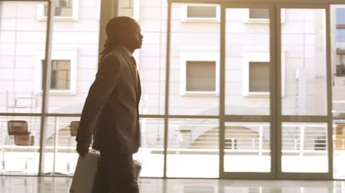 Steadicam Shot Of African American Man Shaking Hands With Business Associate In Modern Glass Offi...