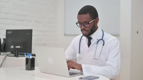Doctor Using Laptop in Bright Office Setting