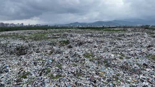 Aerial view of city garbage dump on background of sea. Dump near resort town on seashore in Batumi,
