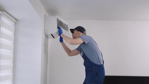 Man Repairing Wall Air Conditioning Unit