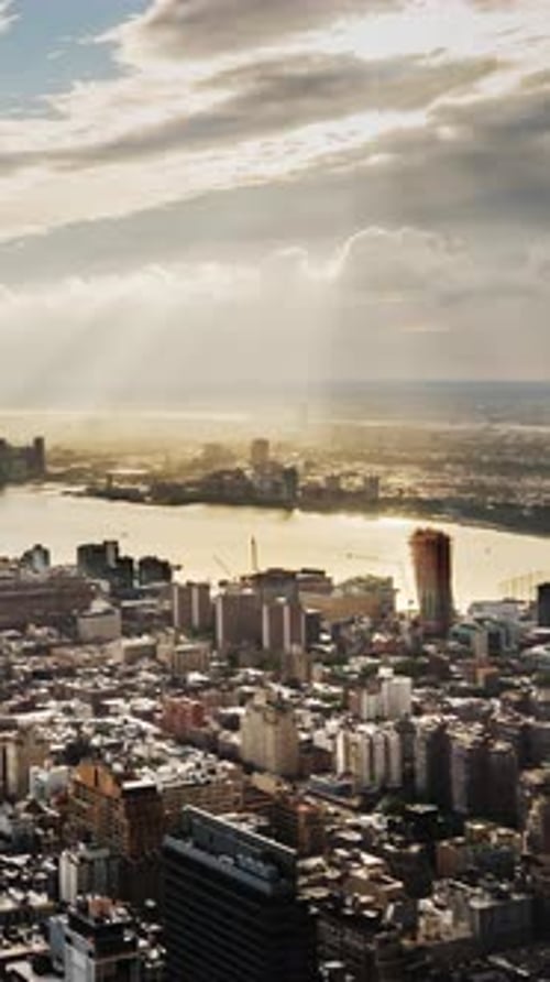 Sun Rays Beautifully Illuminate the River with New York City Skyscrapers in the Foreground Vertical