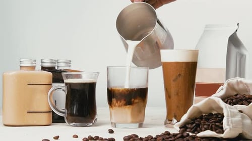 Pouring Cream into a Coffee Glass to Make Latte