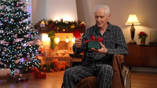 Senior Man in Wheelchair Opening Christmas Present