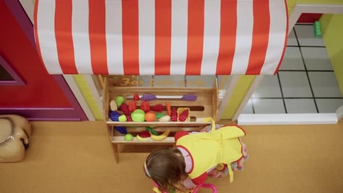 Children Putting Toy Vegetables and Fruits From a Baskets on Shelf in the Shop in the Game Center