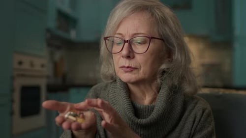 Senior Woman Counting Pills On Hand