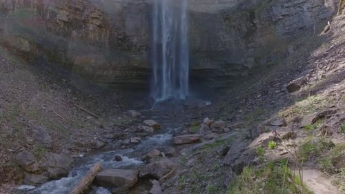 Cachoeira majestosa caindo em cascata em um sereno riacho rochoso cercado por uma vegetação exuberante