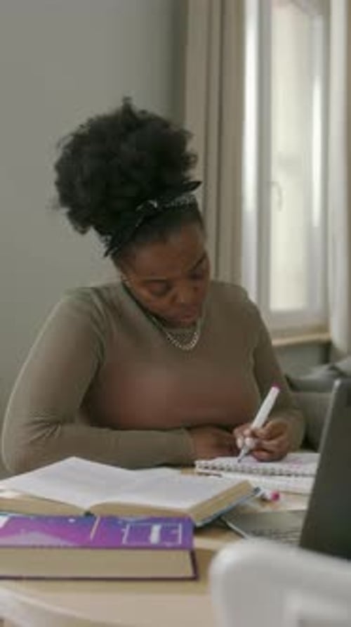 Woman Studies at Desk with Laptop and Textbook