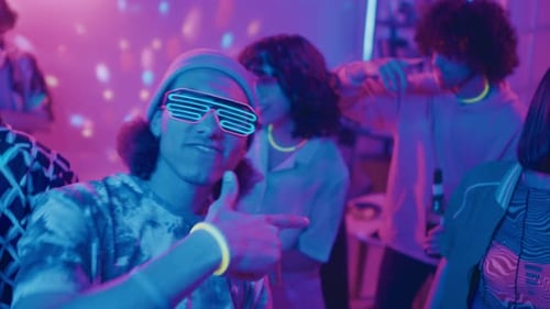 Young Adults Dancing with Glow Sticks at a Party