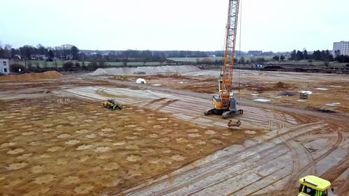 Compactación dinámica del suelo: una grúa alta deja caer un gran peso sobre los cimientos de una enorme construcción