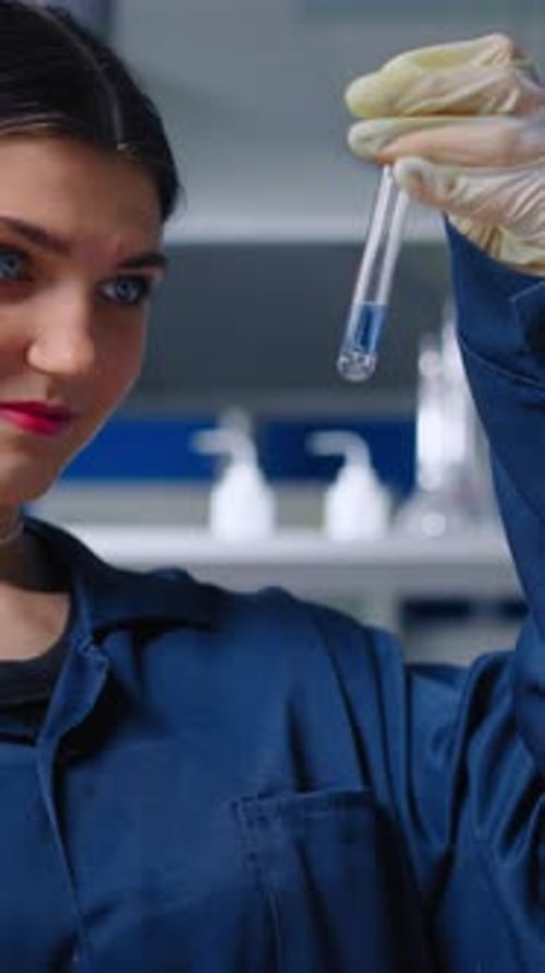 Focused Woman Holding Test Tube in Science Lab