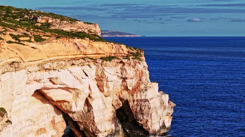 Scenic aerial view of Malta's coastal cliffs alongside the blue sea