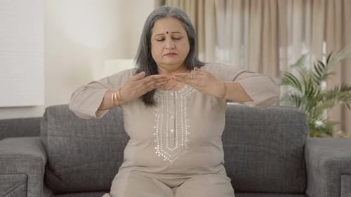 Woman Practices Mindful Breathing on Sofa Indoors