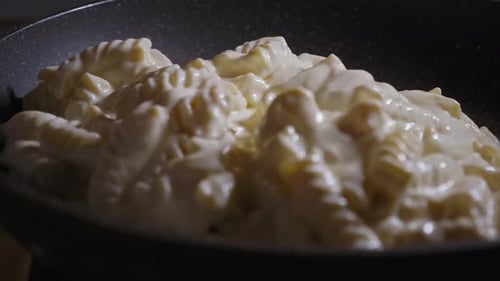 Close-up View Of Hand Adding The Cheese Pie Ingredients To A Frying Pan - Steady Shot