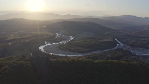 Bird's eye view of river estuary and mountain ridge in the background on the sunset. Russia, Far Eas