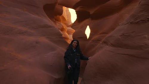 Junge Frau spaziert am Antelope Canyon, Arizona, glatte, gewellte Sandsteinwände.