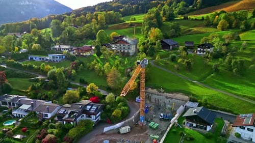 Gran grúa de construcción sobre un sitio de construcción en la ladera de una pintoresca ciudad europea
