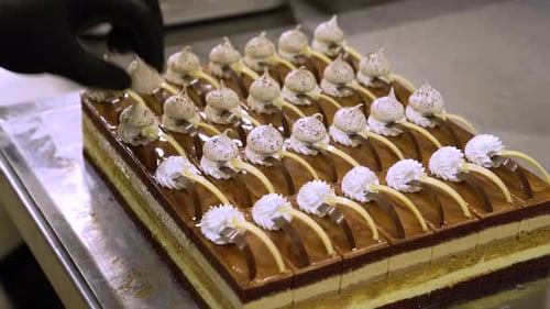 Pastry Chef Decorating Cake Portions in Professional Kitchen