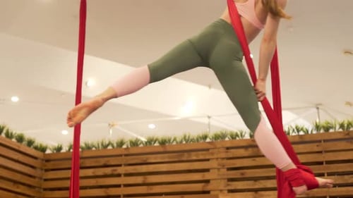 A close up video of gymnast and her legs floating in the air in one position. Her legs are far fro