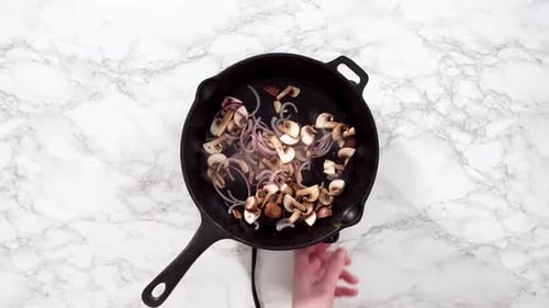Mushrooms and Onions Sizzle in Skillet