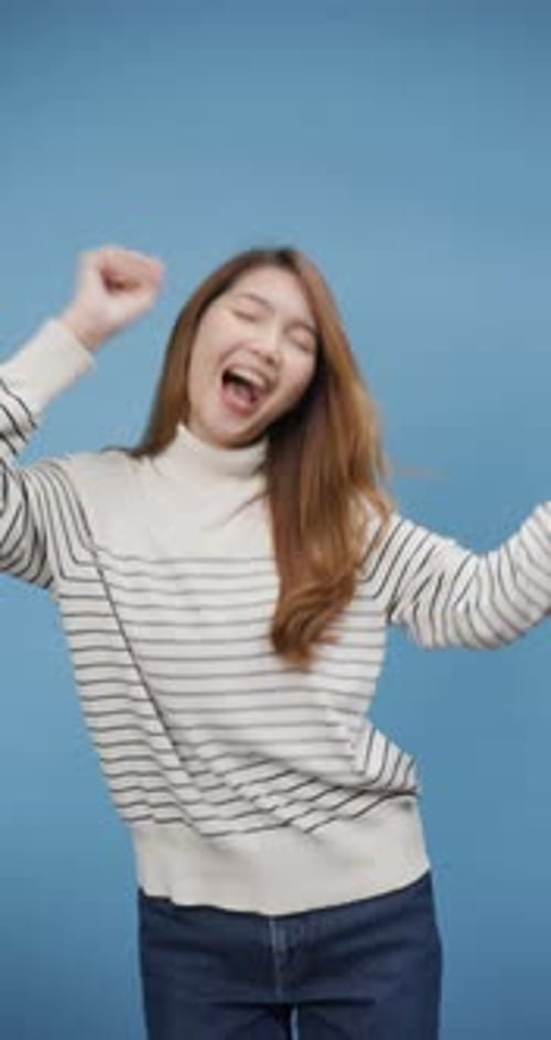 Excited Woman Cheering Against a Blue Background