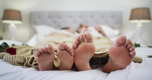 Couple Lying in Bed Surrounded by Roses
