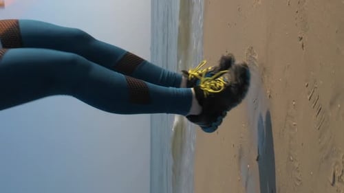 Woman Runs on Beach Near Ocean Waves