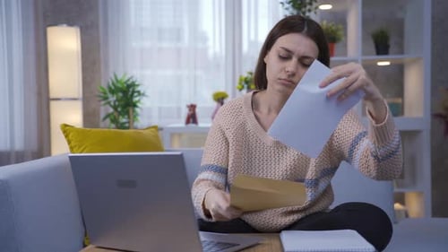 Worried Woman Reading a Letter at Home